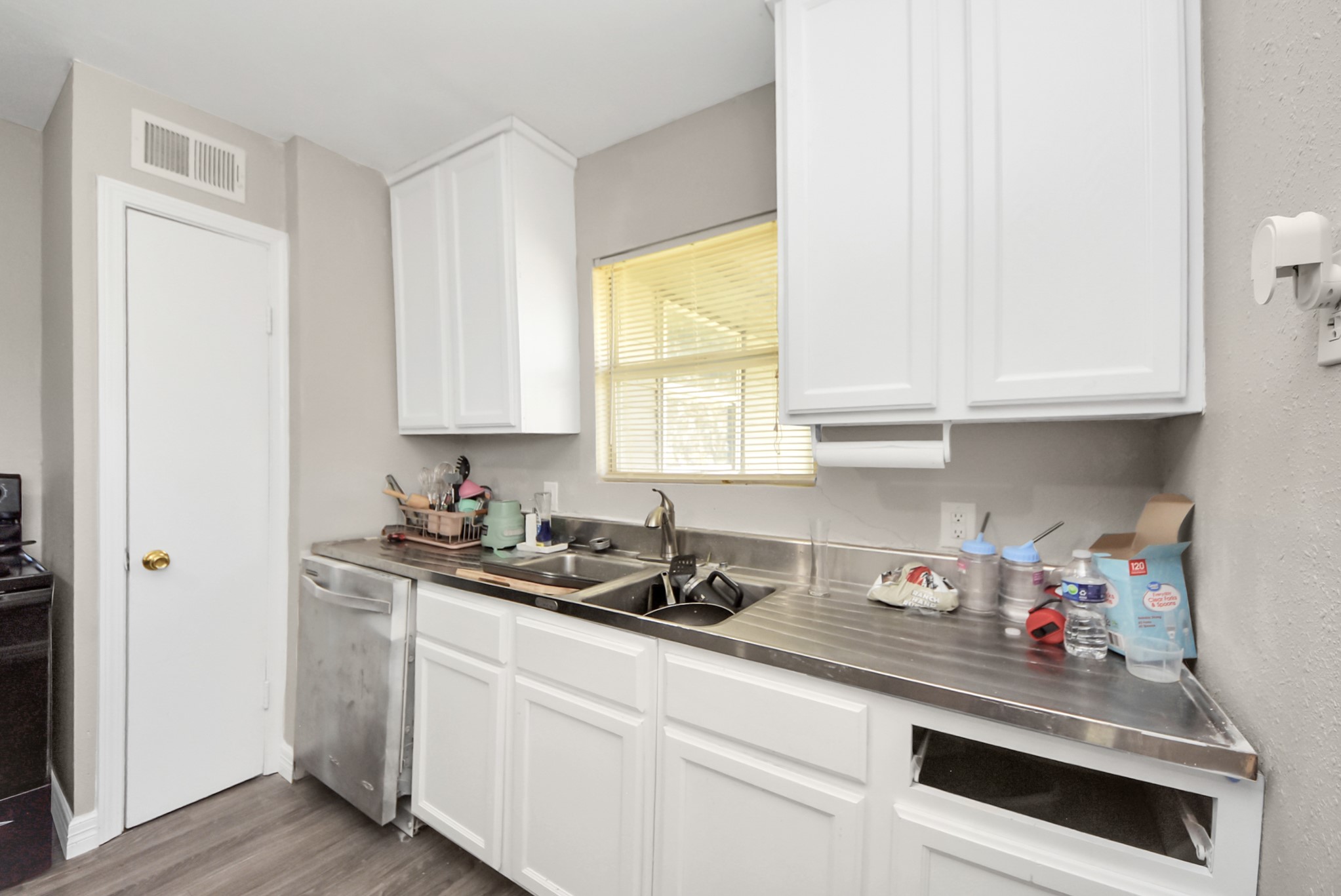 817 Church Street Crosby, TX 77532 - Photo 9 of 18 a kitchen with stainless steel appliances white cabinets and a window