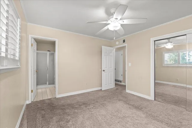 a view of a room with a ceiling fan and a bathroom