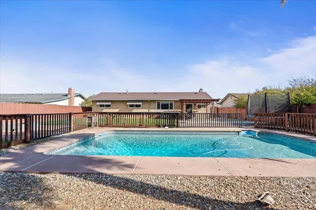 a view of a house with backyard and fence