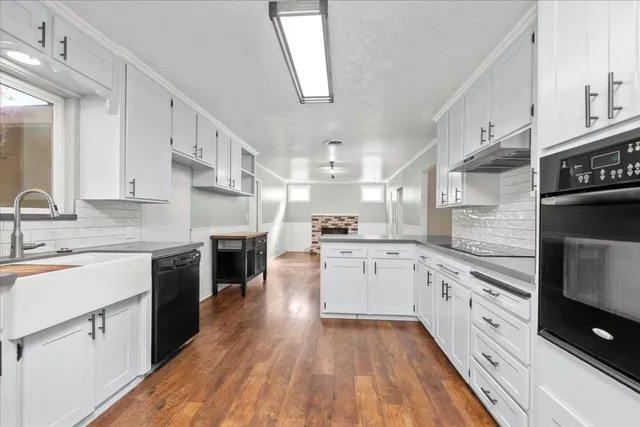 a large kitchen with cabinets wooden floor and stainless steel appliances