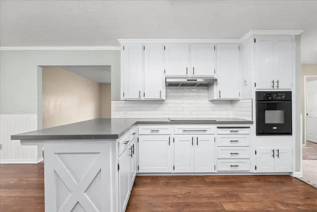 a kitchen with stainless steel appliances white cabinets and a stove top oven