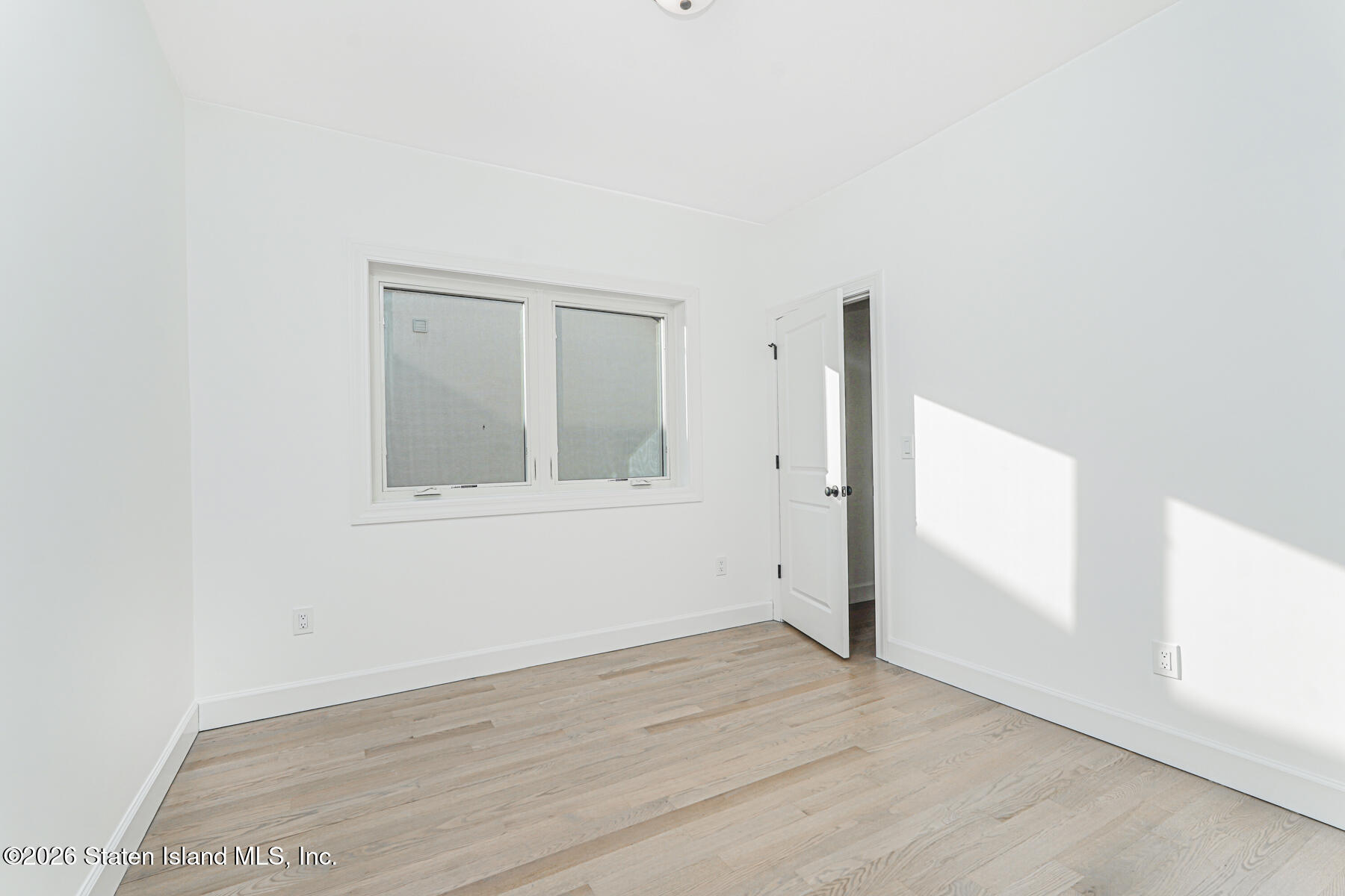 909 Rathbun Avenue Staten Island, NY 10309 - Photo 26 of 35 an empty room with wooden floor and windows