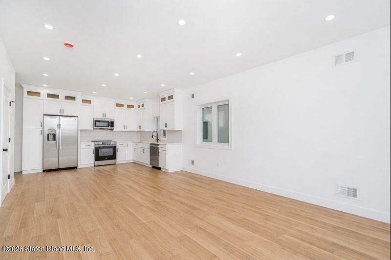 909 Rathbun Avenue Staten Island, NY 10309 - Photo 5 of 35 a view of a kitchen with stainless steel appliances wooden floor and windows
