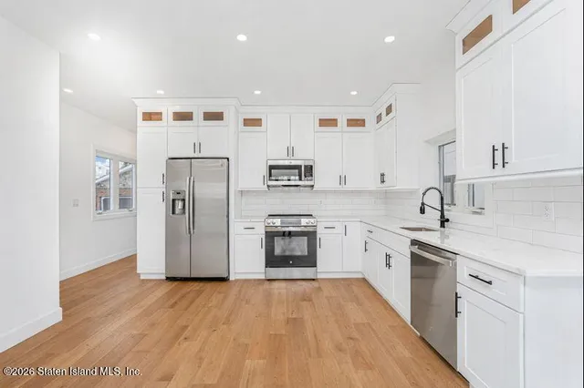 a kitchen with stainless steel appliances granite countertop a refrigerator and a stove top oven