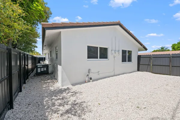 a backyard of a house with basket ball court and wooden floor