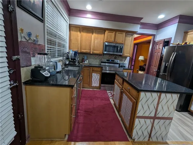 a kitchen with stainless steel appliances granite countertop a refrigerator a stove top oven a sink and dishwasher