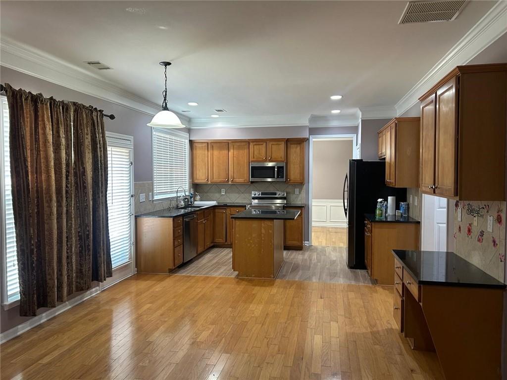 815 Earlham Drive Suwanee, GA 30024 - Photo 7 of 30 a kitchen with stainless steel appliances granite countertop a refrigerator a sink dishwasher a stove and a refrigerator with wooden floor