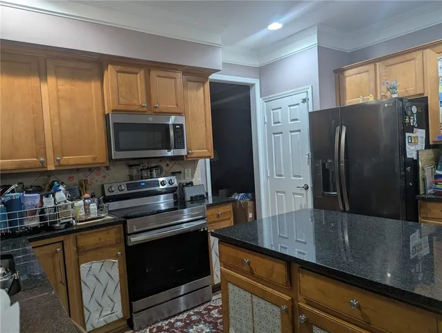 a kitchen with stainless steel appliances a refrigerator stove and microwave
