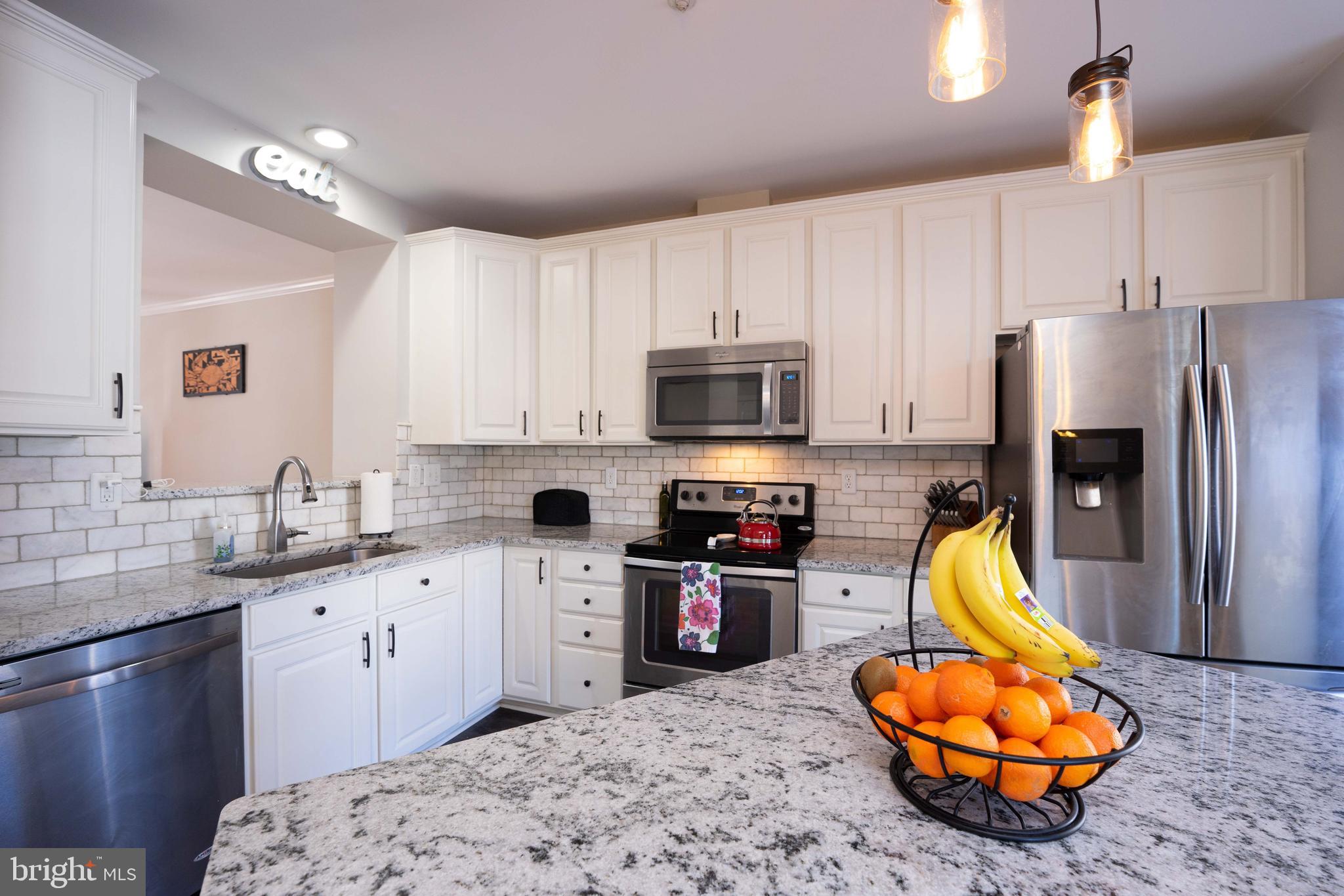 2170 Sewanee Drive Forest Hill, MD 21050 - Photo 11 of 34 a kitchen with stainless steel appliances kitchen island granite countertop a sink dishwasher stove and refrigerator with wooden floor