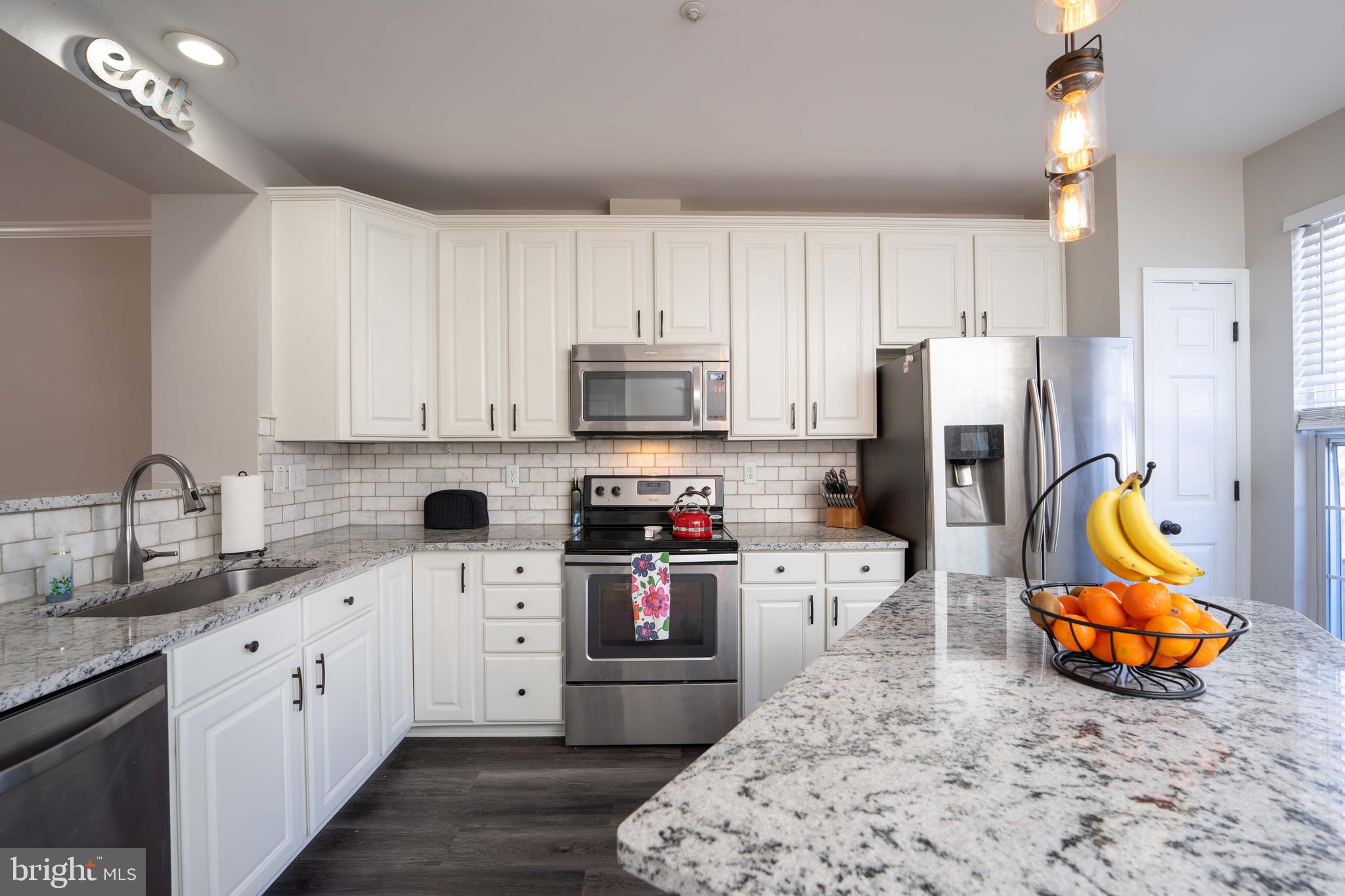 2170 Sewanee Drive Forest Hill, MD 21050 - Photo 10 of 34 a kitchen with stainless steel appliances kitchen island granite countertop a refrigerator a stove a sink dishwasher and white cabinets with wooden floor