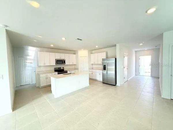 a view of kitchen with stainless steel appliances a refrigerator and a stove top oven