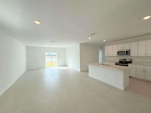 a kitchen with stainless steel appliances a refrigerator sink and white cabinets