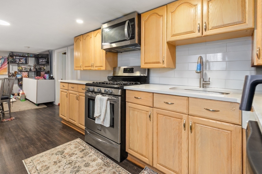 14 Bay Road Revere, MA 02151 - Photo 20 of 38 a kitchen with stainless steel appliances granite countertop a stove a sink and a microwave
