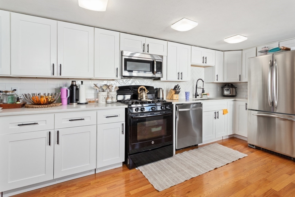 14 Bay Road Revere, MA 02151 - Photo 3 of 38 a kitchen with cabinets stainless steel appliances and wooden floor