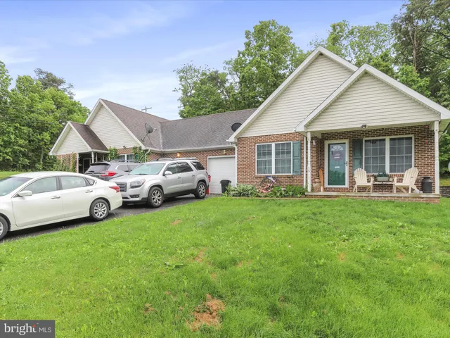 a view of front a house with a garden and parking space