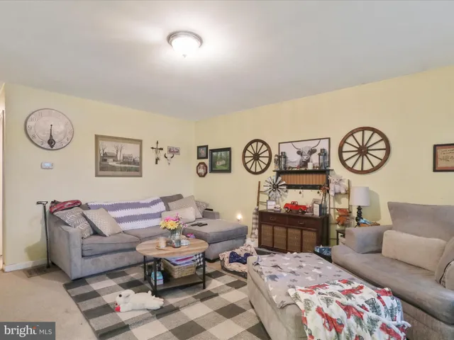 a living room with furniture and paintings on the wall