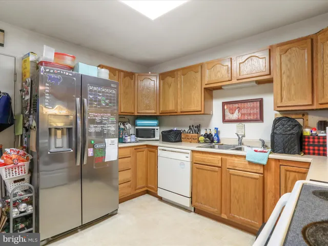 a kitchen with stainless steel appliances granite countertop a refrigerator sink and cabinets