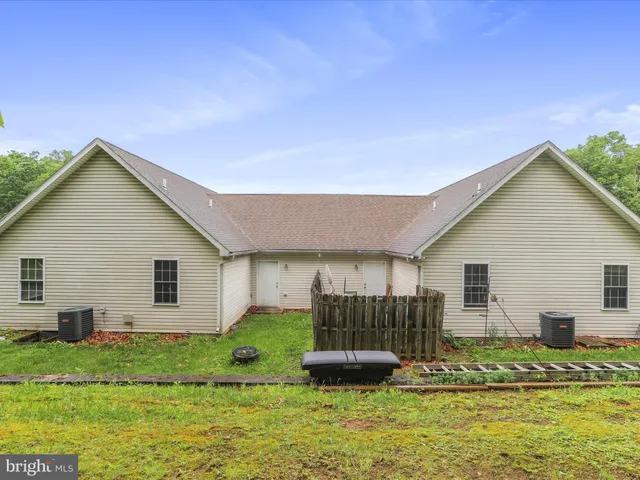 a backyard of a house with potted plants and large tree