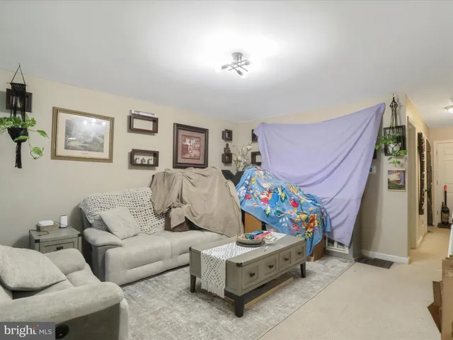 a living room with furniture and baby bed