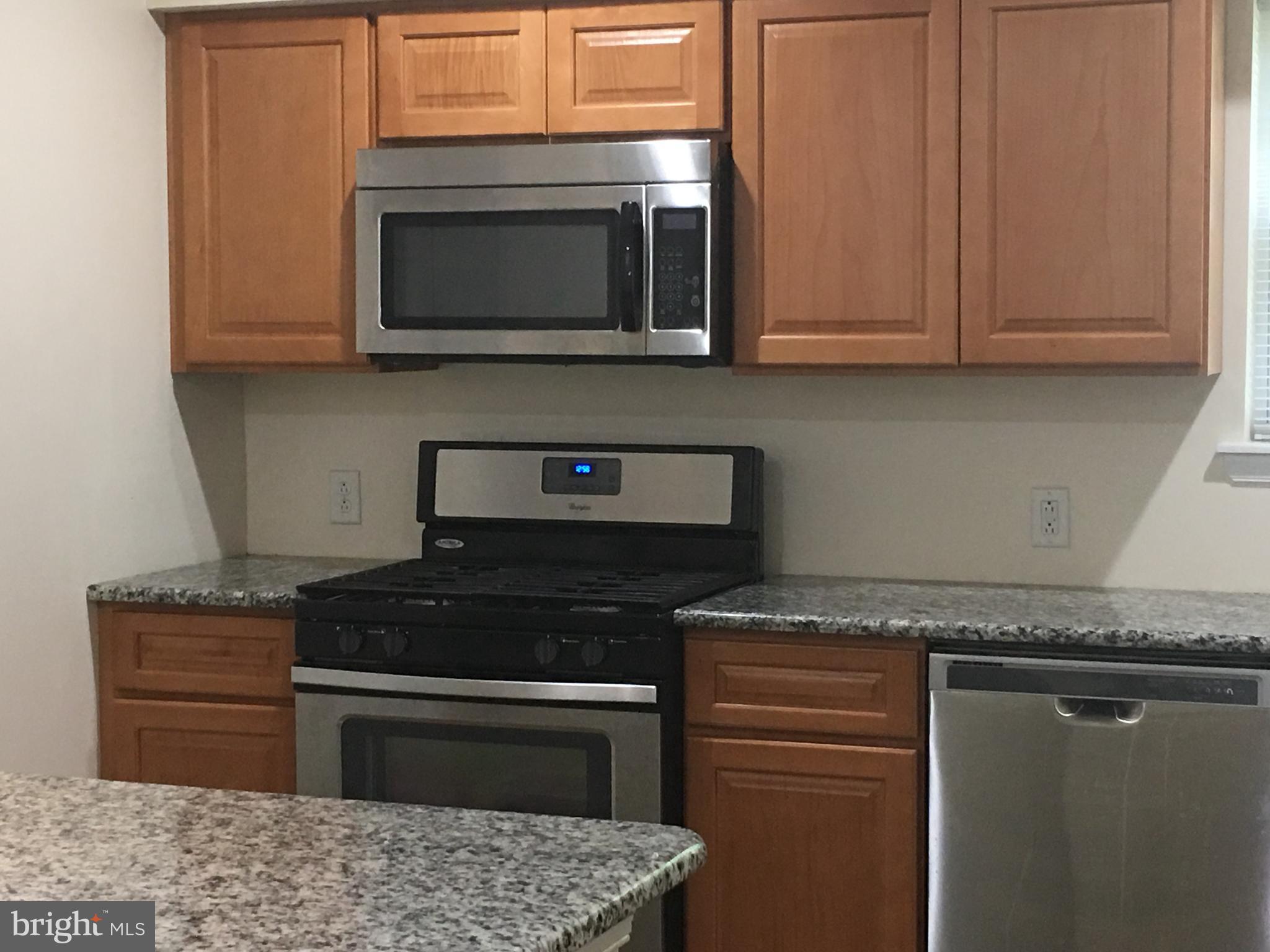 25 Zane Street, Unit A Glassboro, NJ 08028 - Photo 2 of 16 a kitchen with granite countertop cabinets and steel appliances