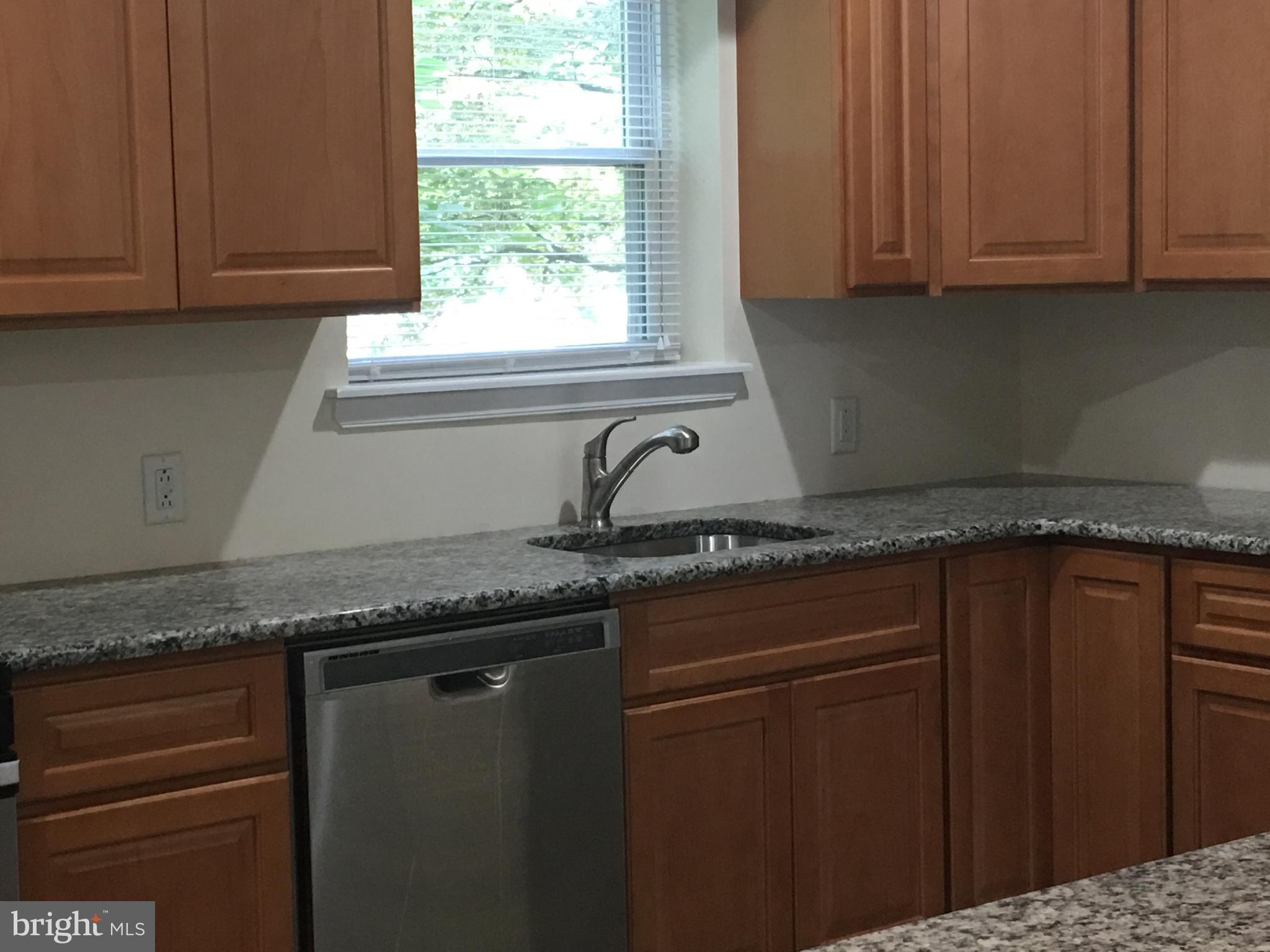 25 Zane Street, Unit A Glassboro, NJ 08028 - Photo 6 of 16 a kitchen with granite countertop cabinets sink and window