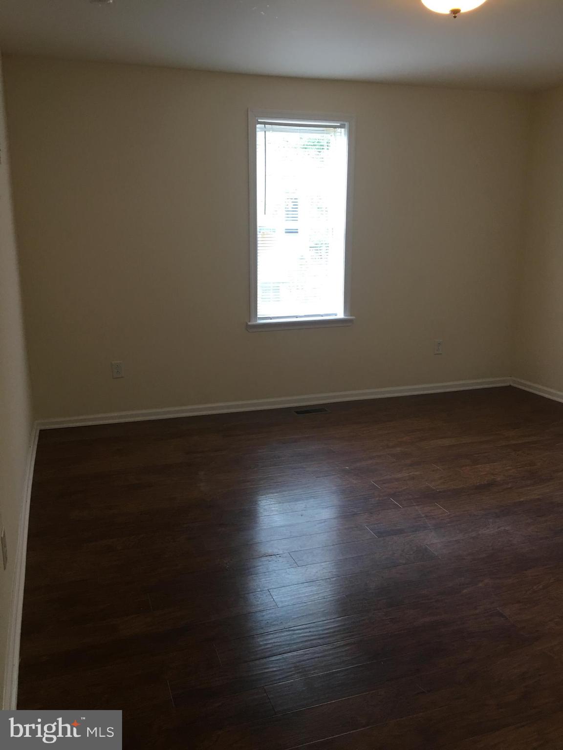 25 Zane Street, Unit A Glassboro, NJ 08028 - Photo 9 of 16 an empty room with wooden floor and windows