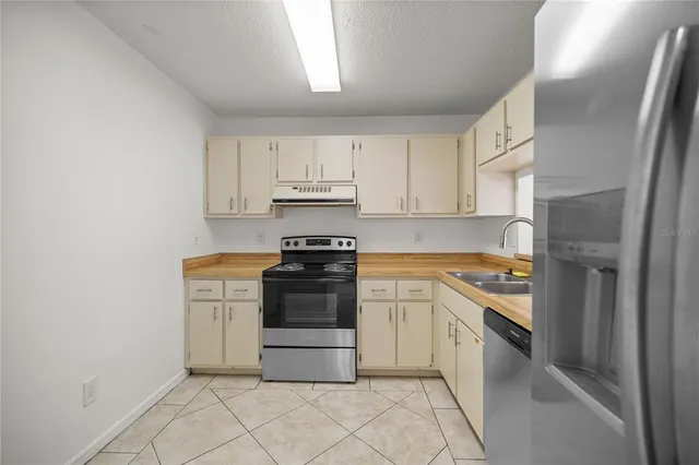 a kitchen with white cabinets and appliances