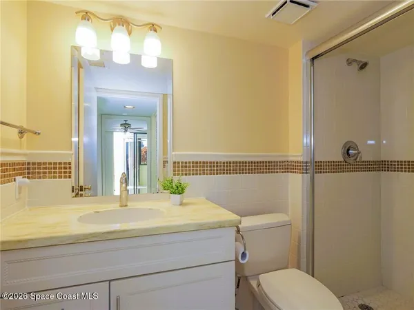 a bathroom with a sink and mirror with toilet