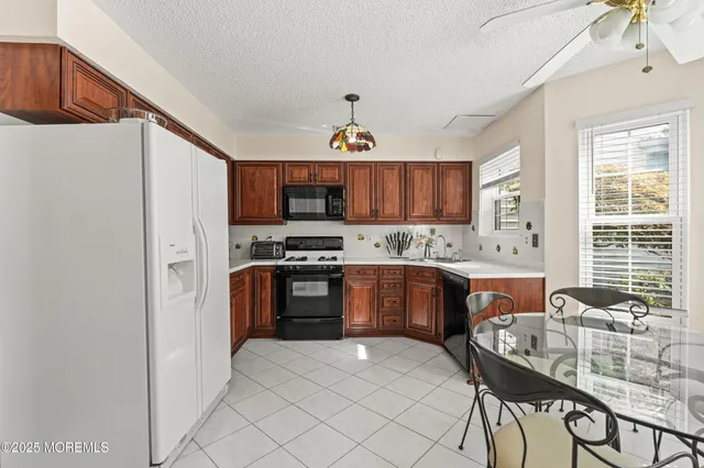 a kitchen with granite countertop a stove cabinets a sink and a refrigerator