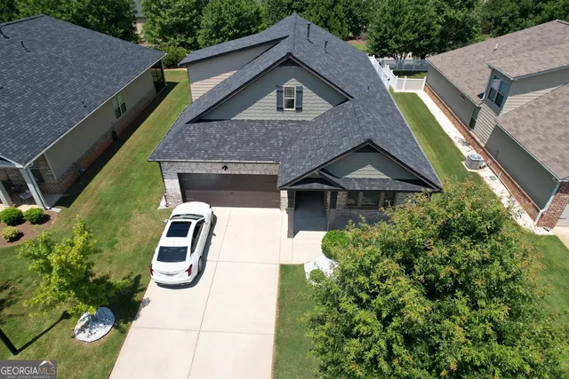 a aerial view of a house with a yard and potted plants