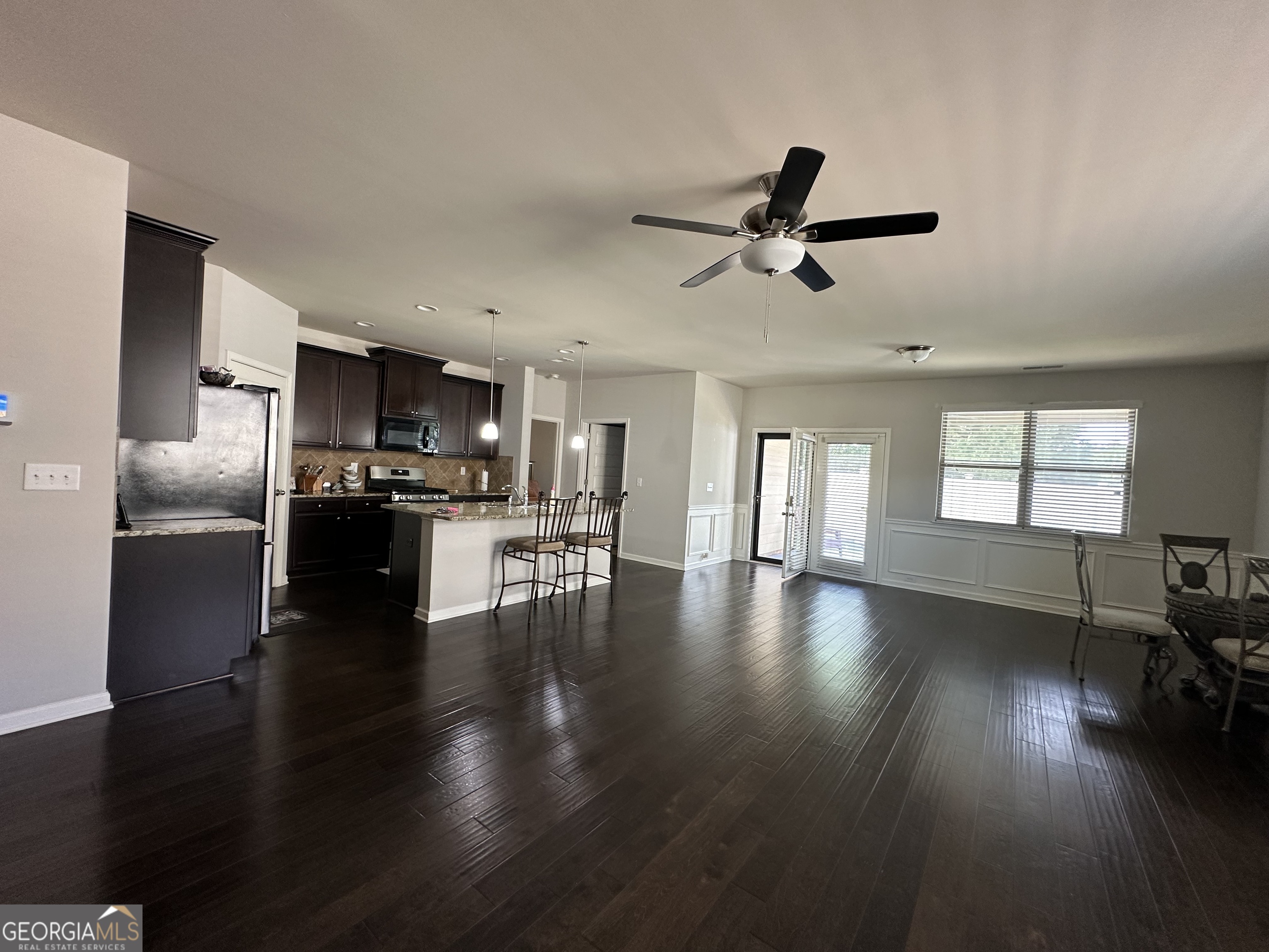 565 Carleton Place Locust Grove, GA 30248 - Photo 23 of 40 a view of a livingroom with furniture wooden floor a ceiling fan and windows