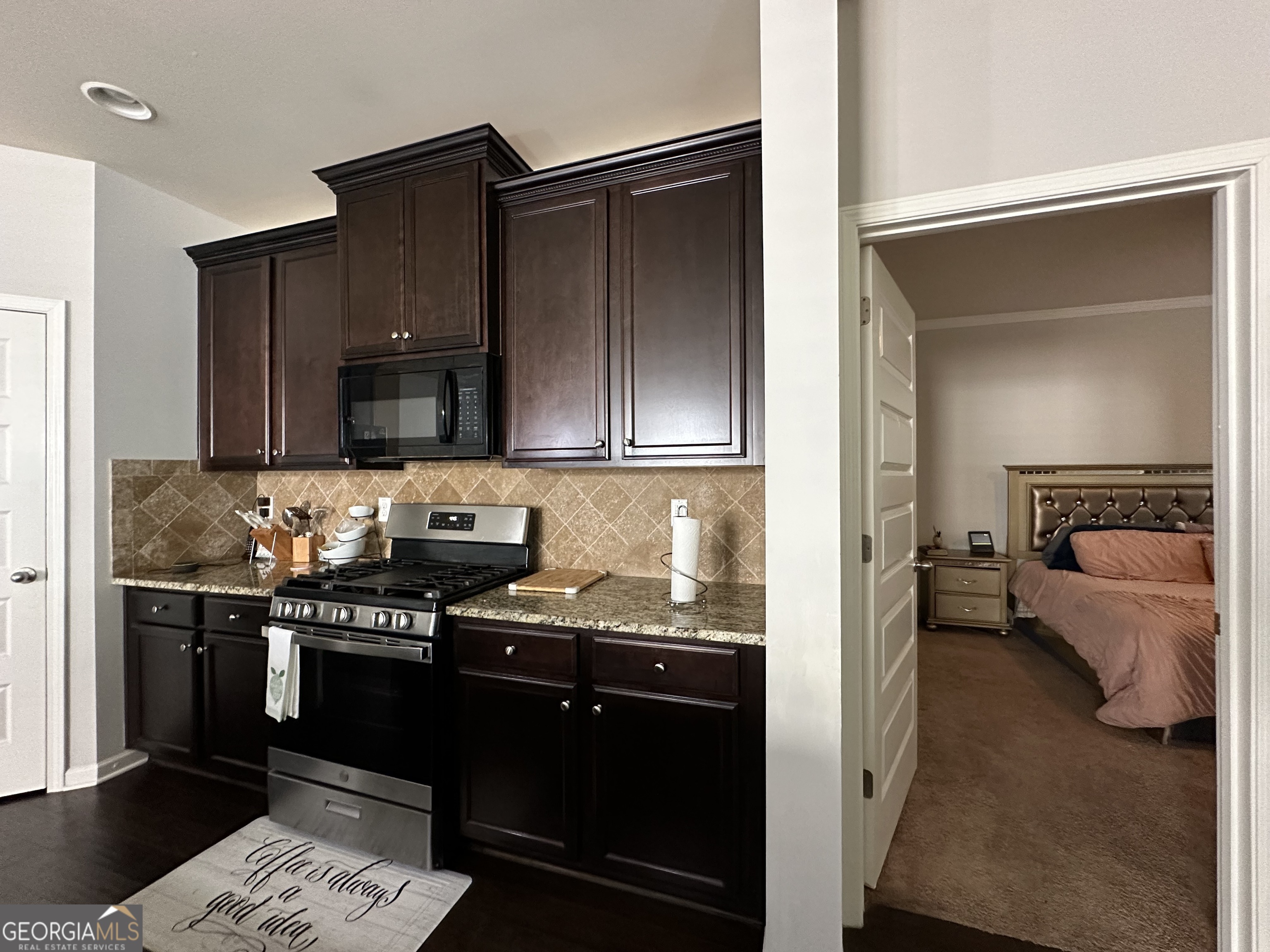 565 Carleton Place Locust Grove, GA 30248 - Photo 25 of 40 a kitchen with granite countertop stainless steel appliances and wooden cabinets