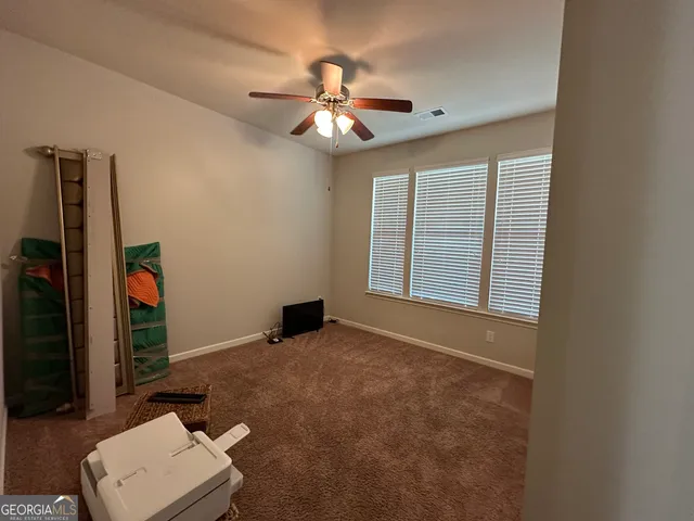 an empty room with closet and a chandelier fan