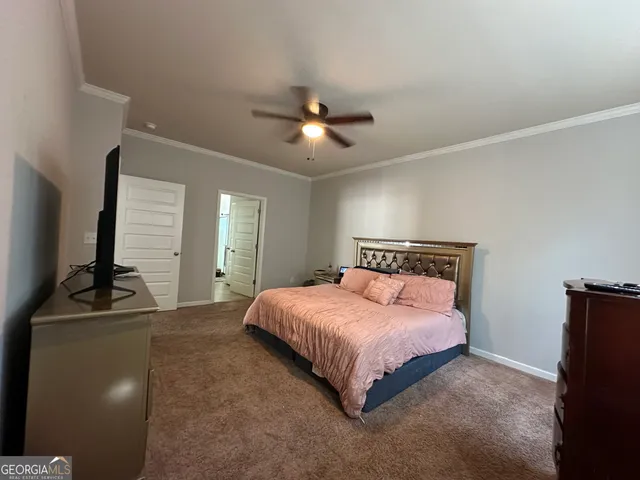 a bedroom with a bed and a flat tv screen on the dresser