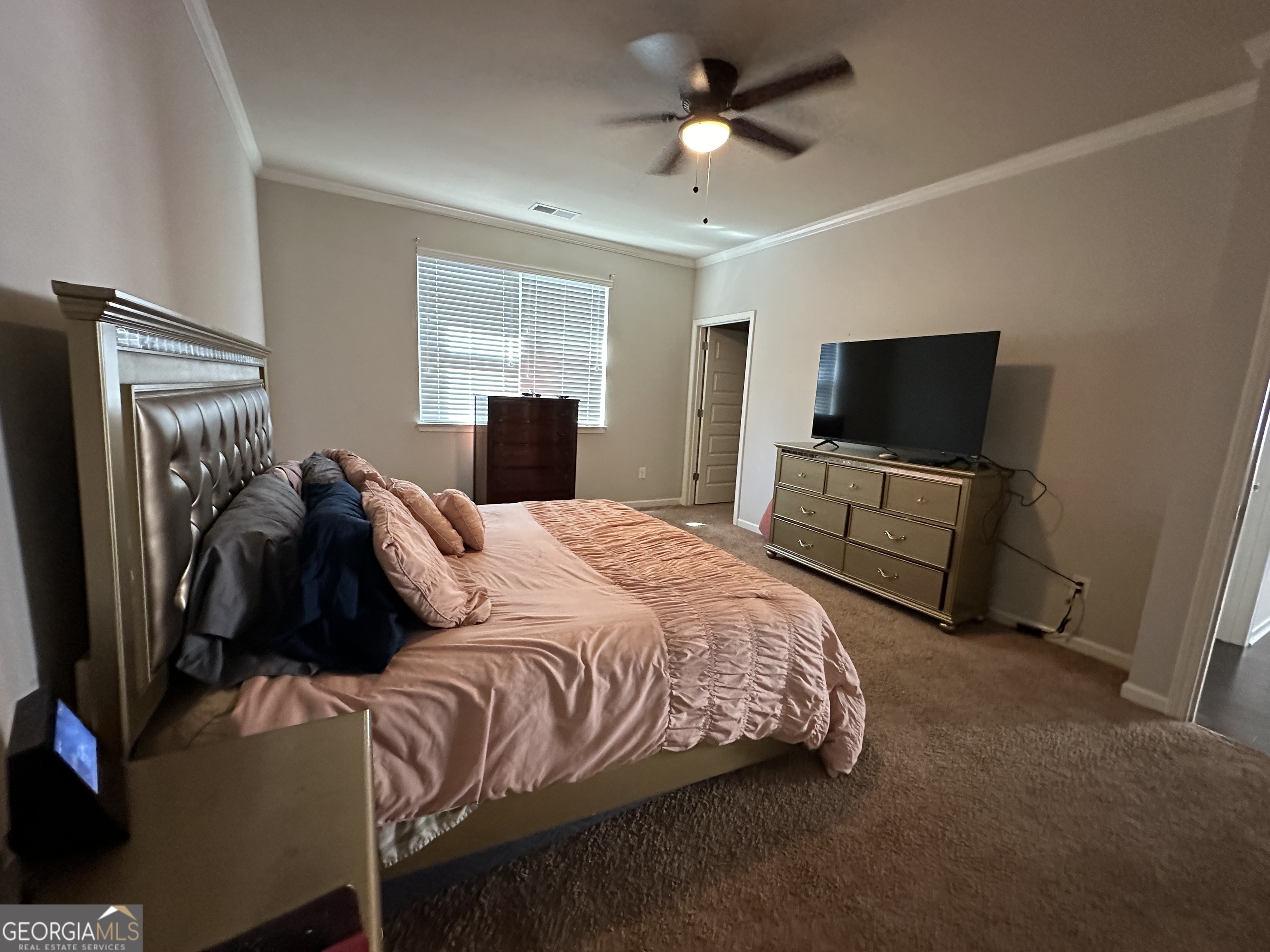 565 Carleton Place Locust Grove, GA 30248 - Photo 34 of 40 a bedroom with a bed and a flat tv screen on the dresser