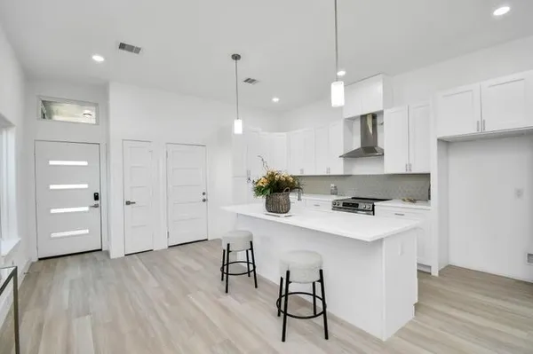 a large white kitchen with lots of furniture a sink appliances and a dining table