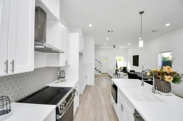 a kitchen with white cabinets and stainless steel appliances