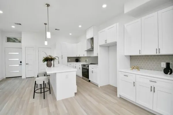 a kitchen with a sink stainless steel appliances and white cabinets