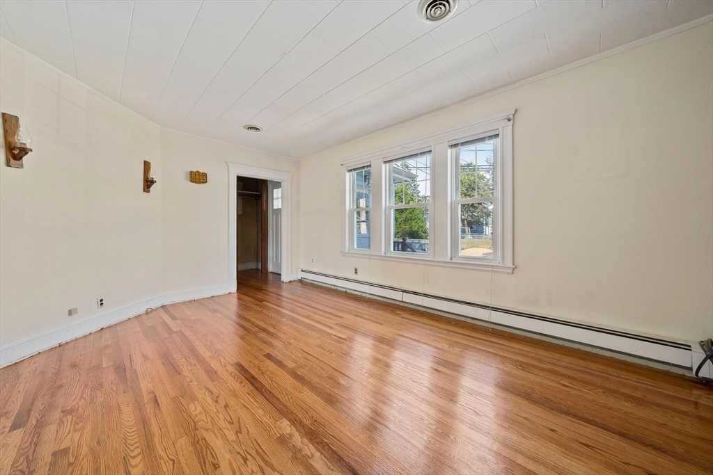 12 Cotuit Street Boston, MA 02132 - Photo 3 of 19 a view of an empty room with wooden floor and a window