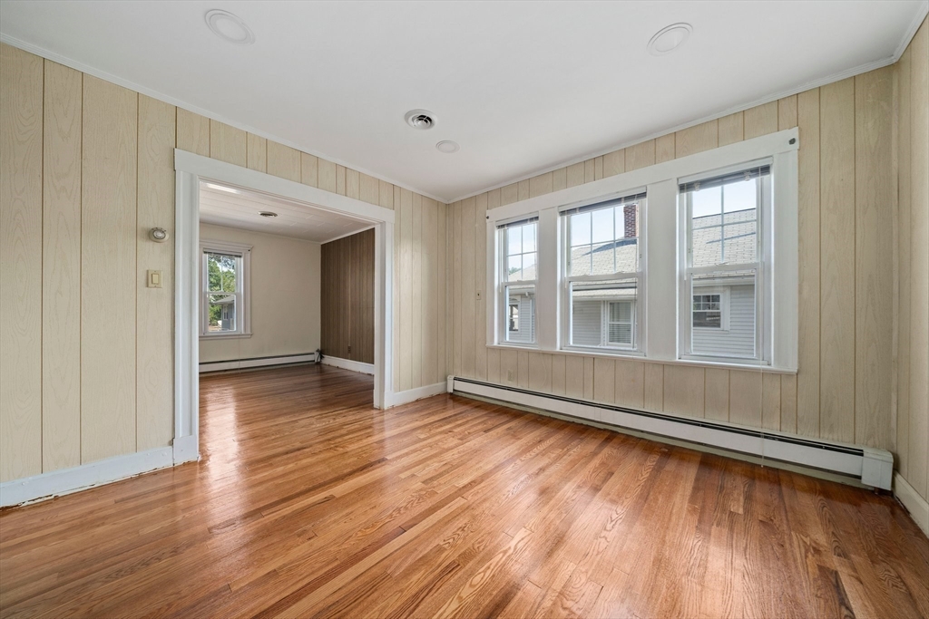 12 Cotuit Street Boston, MA 02132 - Photo 5 of 19 a view of an empty room with wooden floor and a window