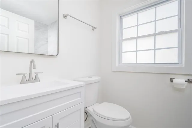 a bathroom with a sink a toilet and a mirror