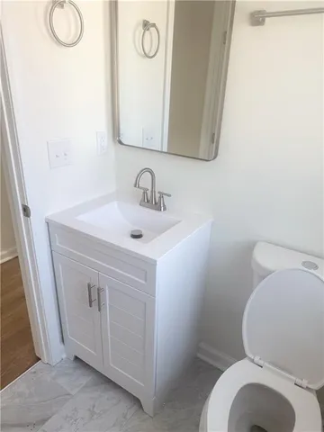 a bathroom with a toilet sink and mirror