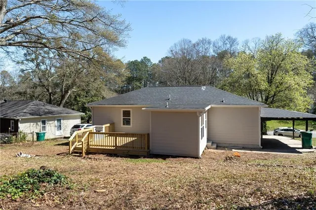 a view of a house with backyard and trees