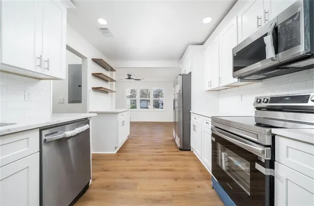 a kitchen with stainless steel appliances granite countertop a refrigerator a stove top oven a sink and dishwasher