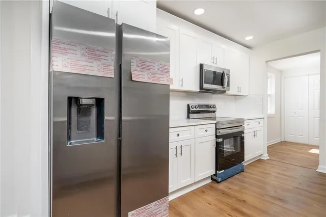 a kitchen with stainless steel appliances granite countertop a refrigerator a stove top oven a sink and dishwasher
