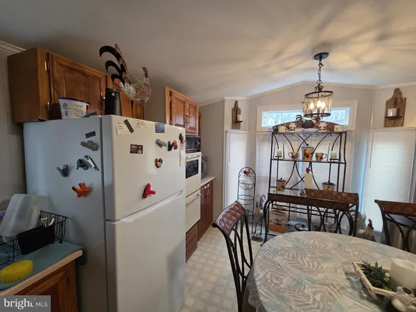 a kitchen with stainless steel appliances a stove a refrigerator and a dining table
