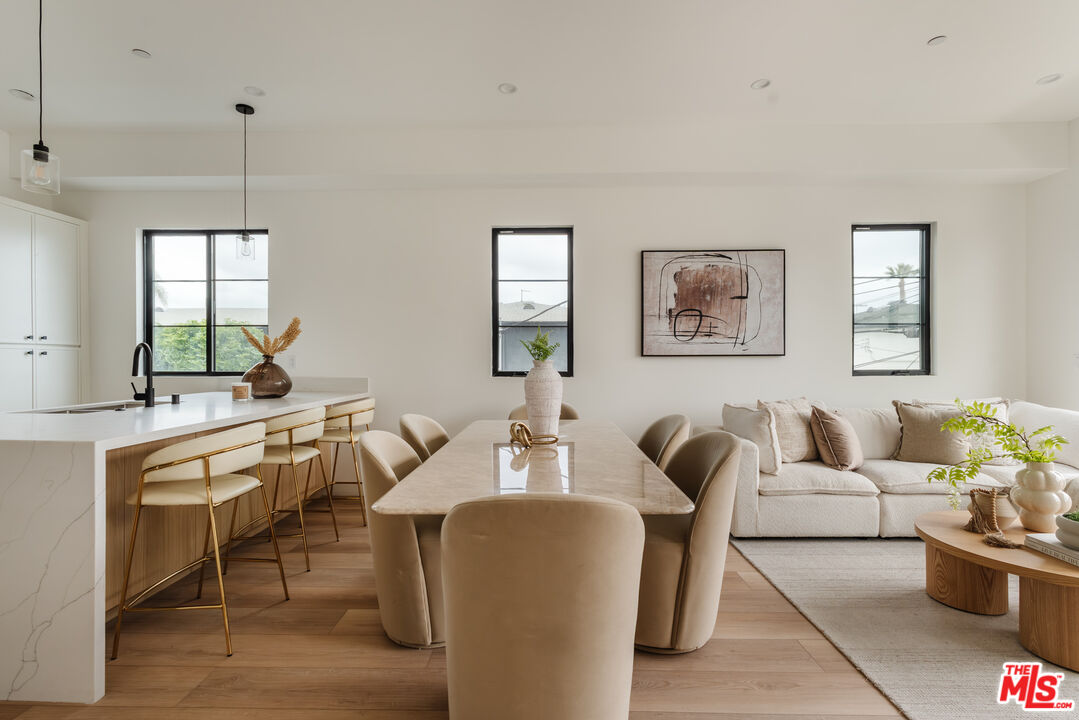 a living room with furniture a dining table and a large window