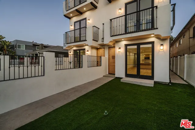 a view of a house with many windows and a yard