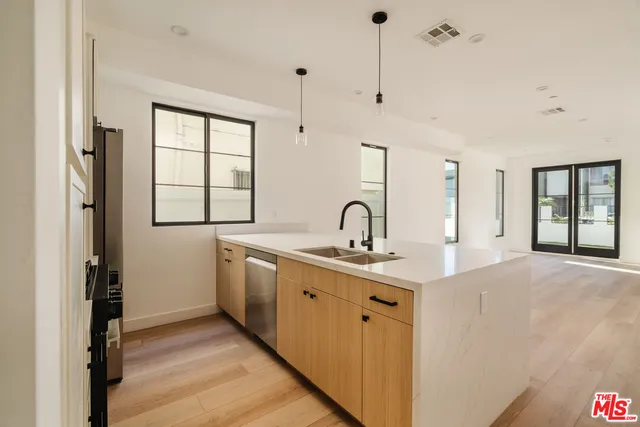 a kitchen with stainless steel appliances granite countertop a sink a window and a refrigerator