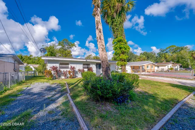 a view of a yard with plants and a fountain